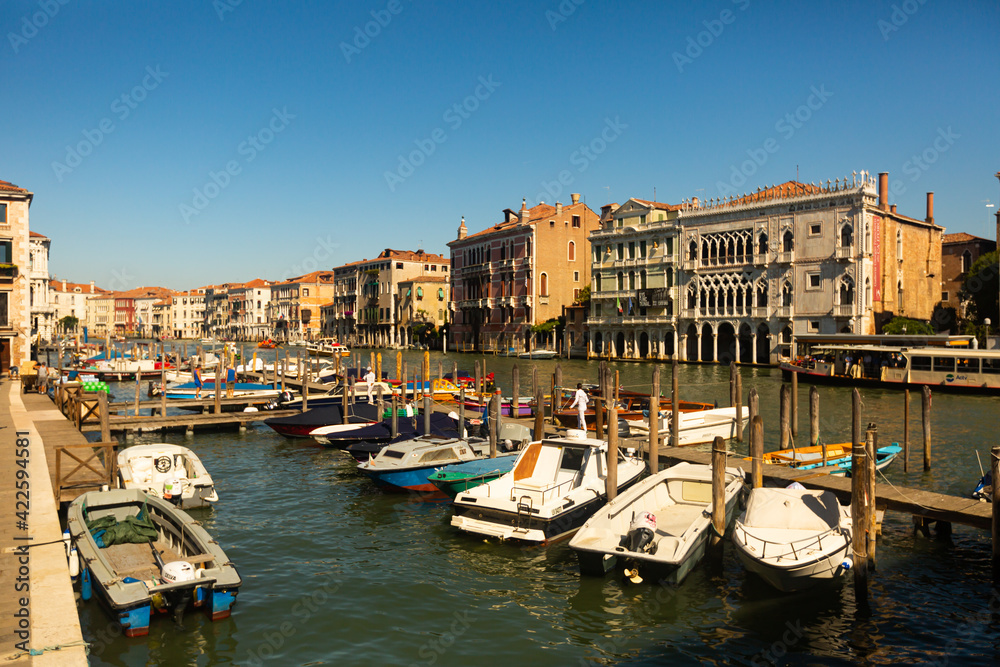 VENICE, ITALY - SEPTEMBER 05, 2019: Motor boats parking in Grand Canal on background of impressive architecture of ancient buildings on banks of canal