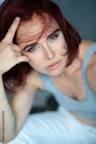 Beautiful young ginger woman wearing casual clothes posing indoor, natural light