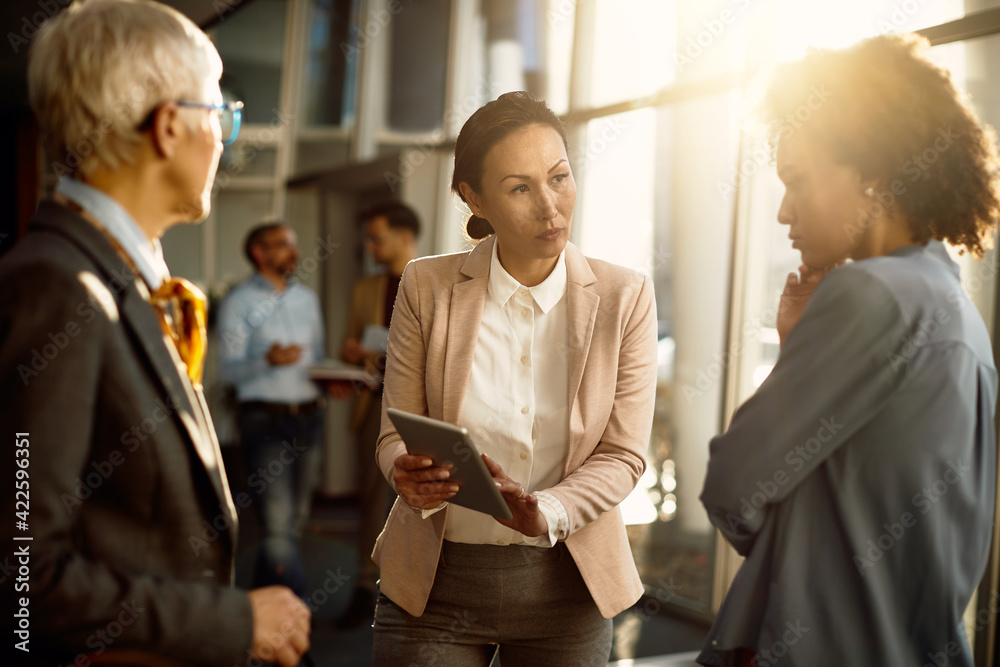 © Drazen - Asian executive director using touchpad while having briefing with her female colleagues at work. © Drazen - Asian executive director using touchpad while having briefing with her female colleagues at work.