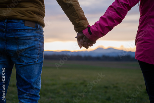 Closeup view of a couple holding hands standing outside