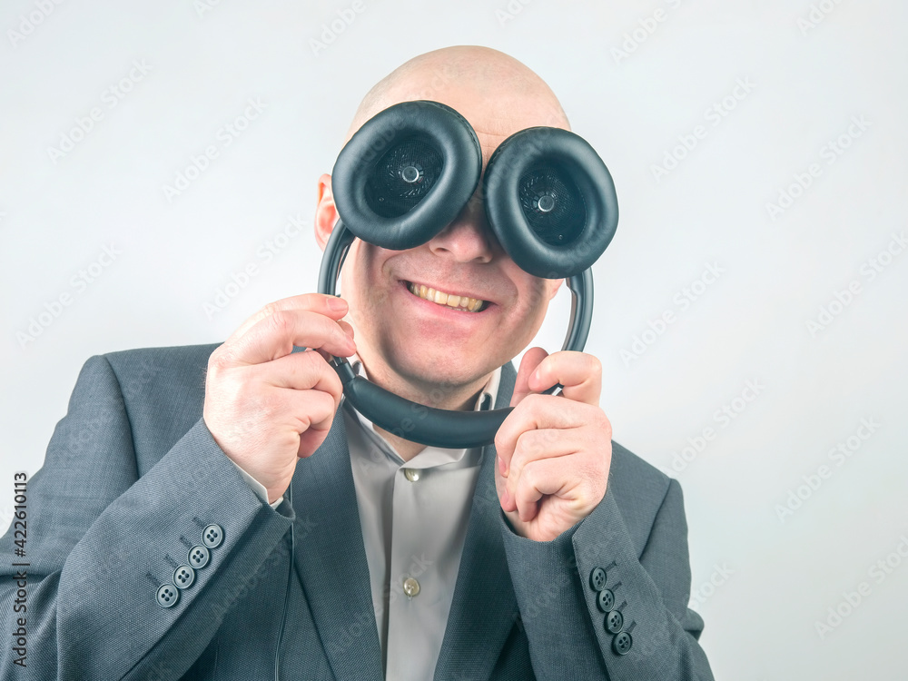 portrait of a cheerful man with headphones near his eyes.
