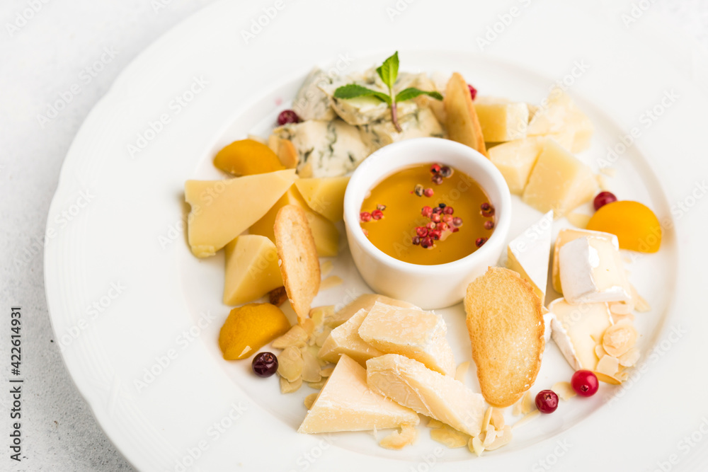  assortment of different cheeses with honey as an appetizer
