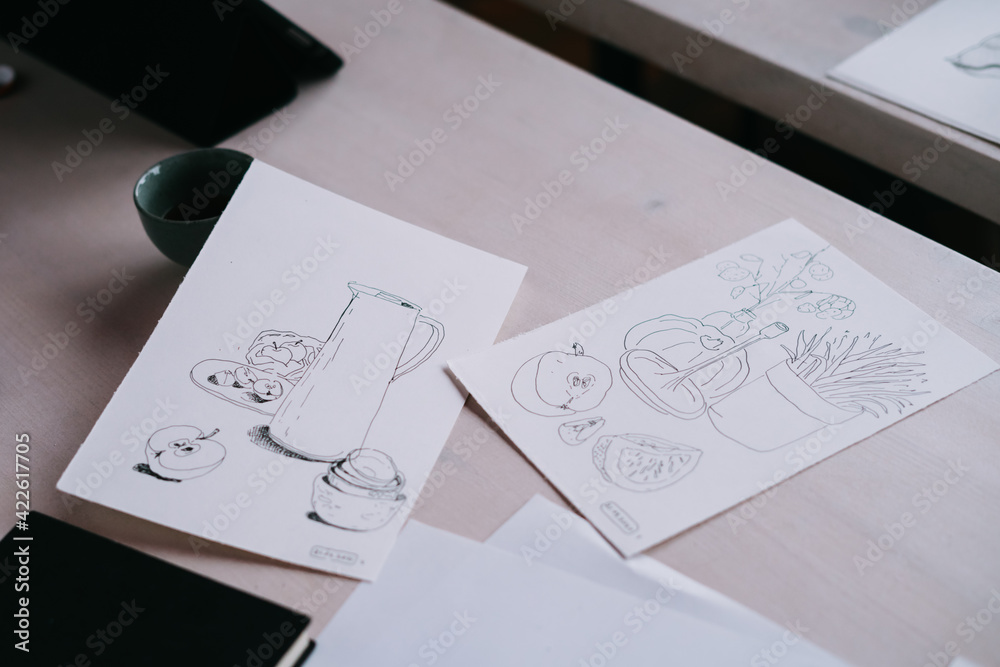 Sketches lie on a white wooden table. Drawing a liner. Sketches lie on a white wooden table. Drawing a liner.