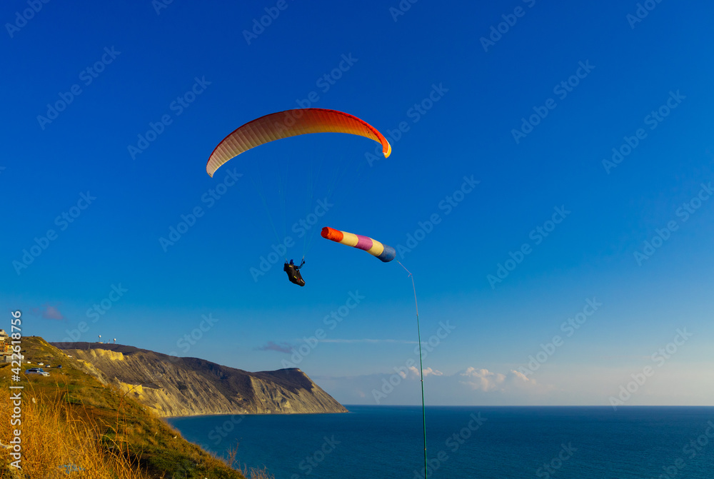 Paragliding in the sky. Paraglider tandem flying over the sea with mountains at sunset Paragliding in the sky. Paraglider tandem flying over the sea with mountains at sunset