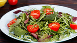 arugula salad and tomatoes on a wooden background