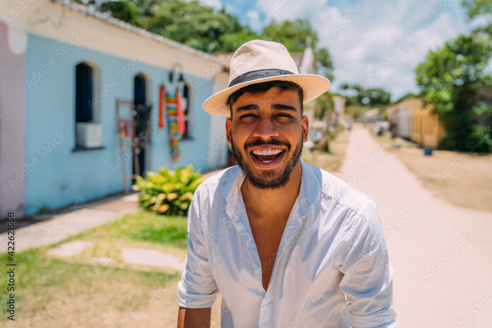 Tourist making selfie in the historic center of Porto Seguro. Latin American man in hat smiling at camera Tourist making selfie in the historic center of Porto Seguro. Latin American man in hat smiling at camera