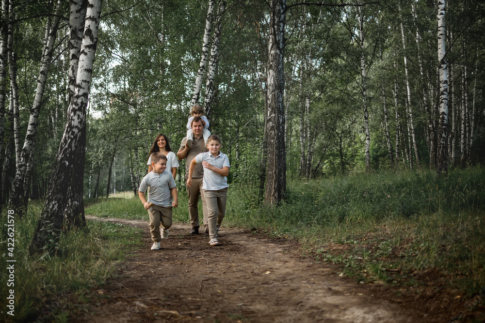 Two elder boys are running a race, their parents and younger brother are cheering for them. Image with selective focus and toning