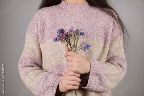 woman  holding blue and pirple flowers photo
