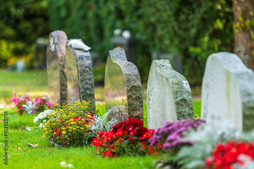 Row of tombstones decorated with colorful flowers photo