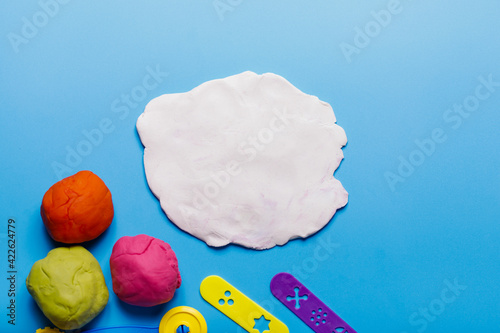 Homemade plasticine, plasticine, play dough on a colored background. Molding clay photo