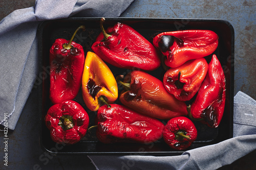 Roasted red and yellow peppers in baking tray.