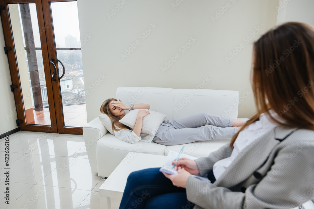 A young girl during depression communicates with a psychologist in the office. Psychological help. A young girl during depression communicates with a psychologist in the office. Psychological help.