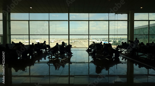 silhouette of people waiting for the plane to leave in the empty airport lounge. Spain, Barcelona International Airport El Prat. photo