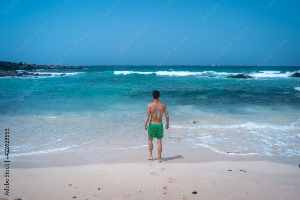 young man on the shore of a white sand beach in Orzola. Lanzarote. Las Palmas. Canary islands young man on the shore of a white sand beach in Orzola. Lanzarote. Las Palmas. Canary islands