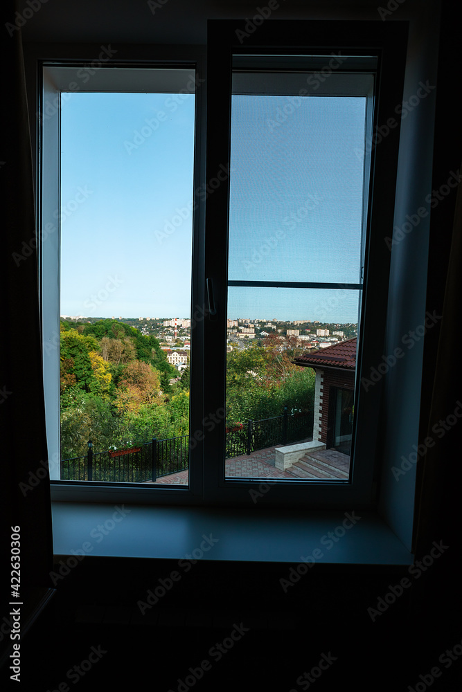 view from the hotel window on the green city. landscape outside the window on a summer day