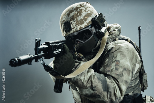 Male special forces soldier in grey winter uniform. Shot in studio on green background.