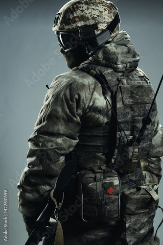 Male special forces soldier in grey winter uniform. Shot in studio on green background.