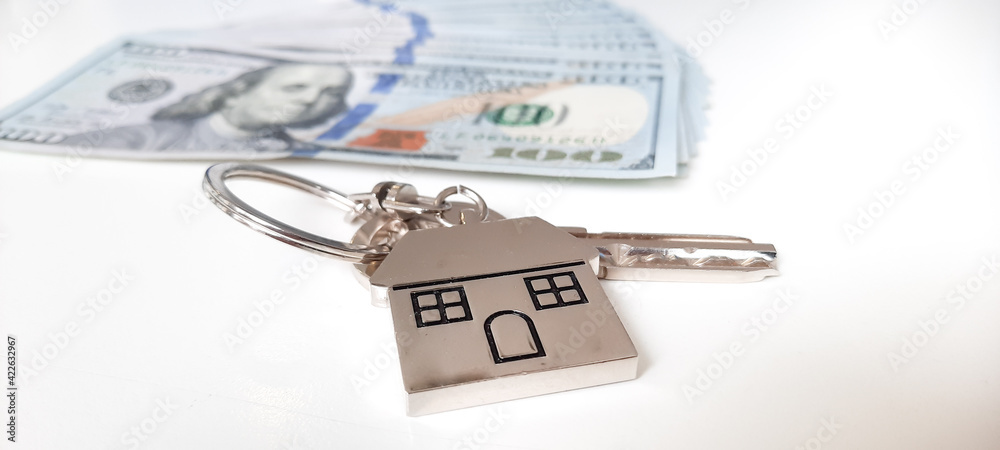 Set of house keys laying on hundred dollar bills stock photo Set of house keys laying on hundred dollar bills stock photo