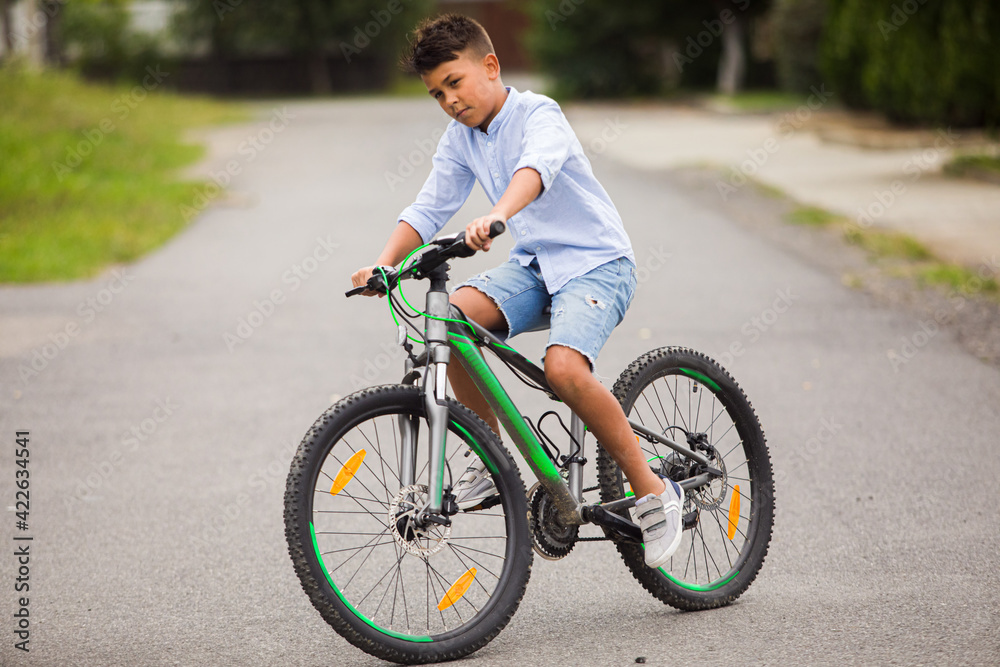 Teenage boy is riding on a bicycle