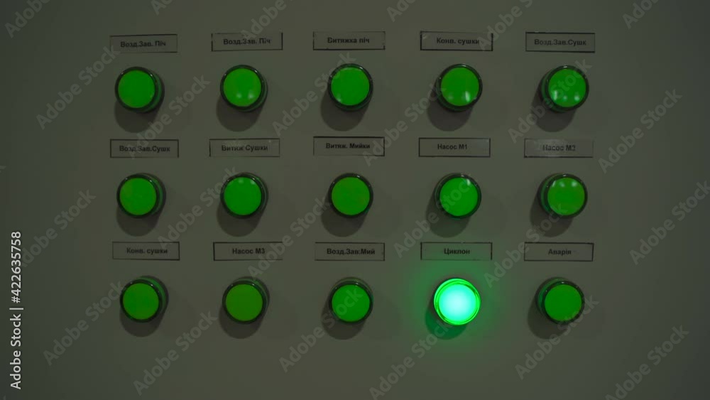 Closeup of lit green buttons lights on manufacturing machinery Closeup of lit green buttons lights on manufacturing machinery