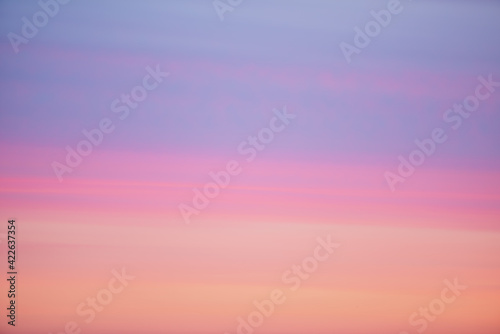Beautiful backdrop of sunset sky of pink orange lilac violet magenta colors. Colorful smooth dawn sky gradient. Nature background of sunrise. Amazing morning heaven. Slightly cloudy evening atmosphere © Daniil