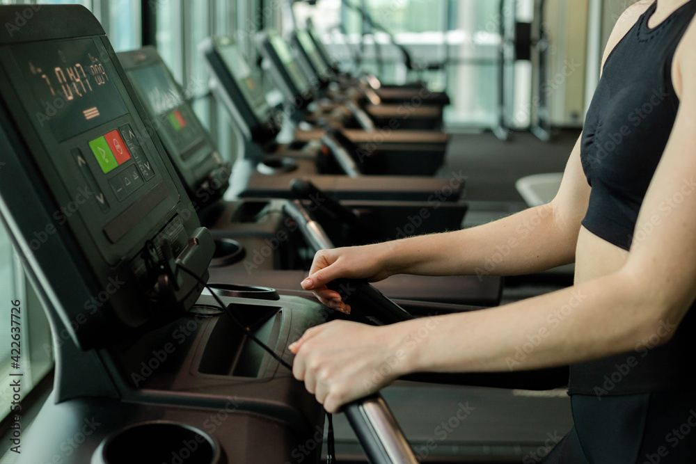 Happy athletic woman jogging on treadmills in a gym. Happy athletic woman jogging on treadmills in a gym.