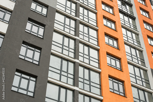 The facade of a multi-storey building with windows and balconies as an element of the architecture of a modern city