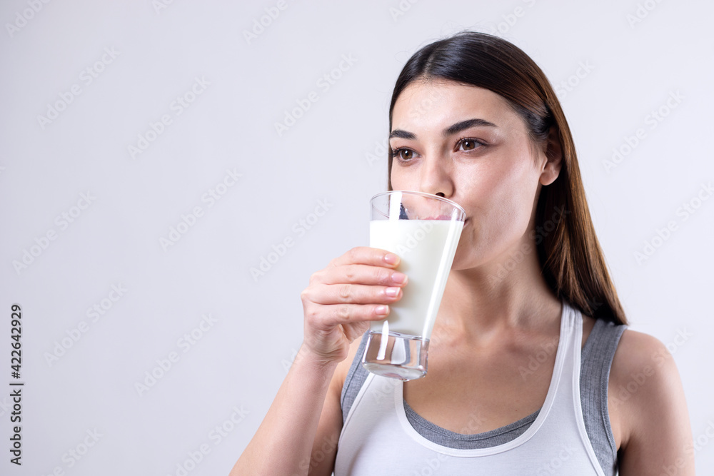 young woman drinking a glass of milk young woman drinking a glass of milk