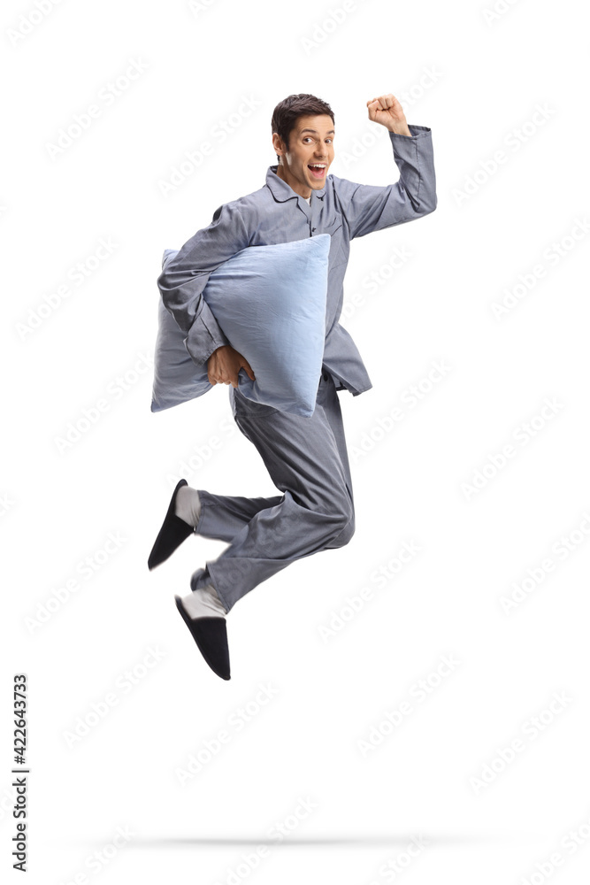 Full length shot of a happy man in pajamas holding a pillow and jumping