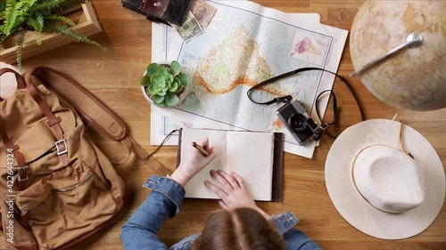 Top view of young woman with maps planning vacation trip holiday, desktop travel concept. photo