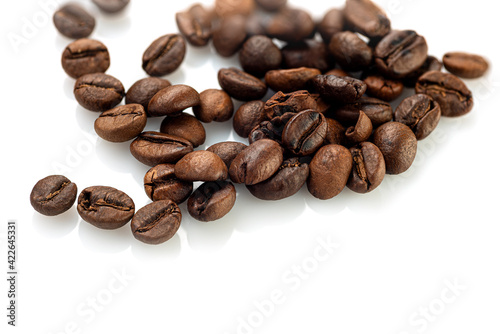 Coffee beans scattered randomly on a white background