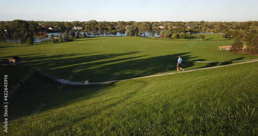 Man walking down stairs for exercise in a park setting in summer Man walking down stairs for exercise in a park setting in summer