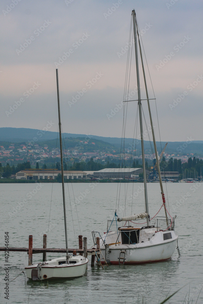 Fototapeta premium Small sailboats moored on the lake of balaton in hungary on a cloudy summer day.