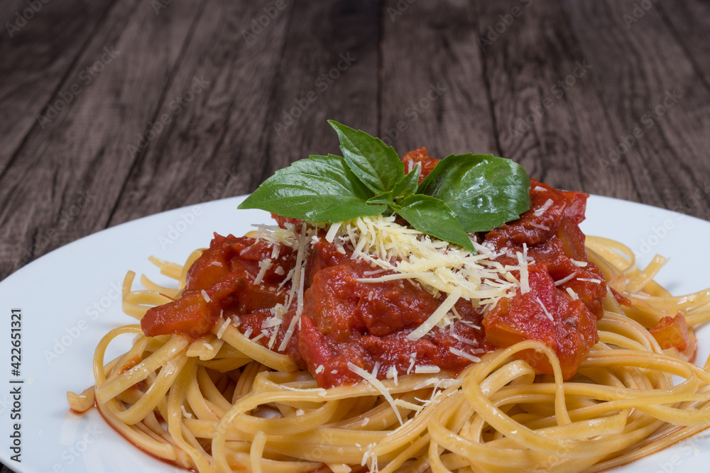 Pasta with rustic tomato sauce, basil leaves and grated cheese. Bavette pasta in red sauce with cheese. Close-up gastronomic photo for restaurants. Pasta with rustic tomato sauce, basil leaves and grated cheese. Bavette pasta in red sauce with cheese. Close-up gastronomic photo for restaurants.