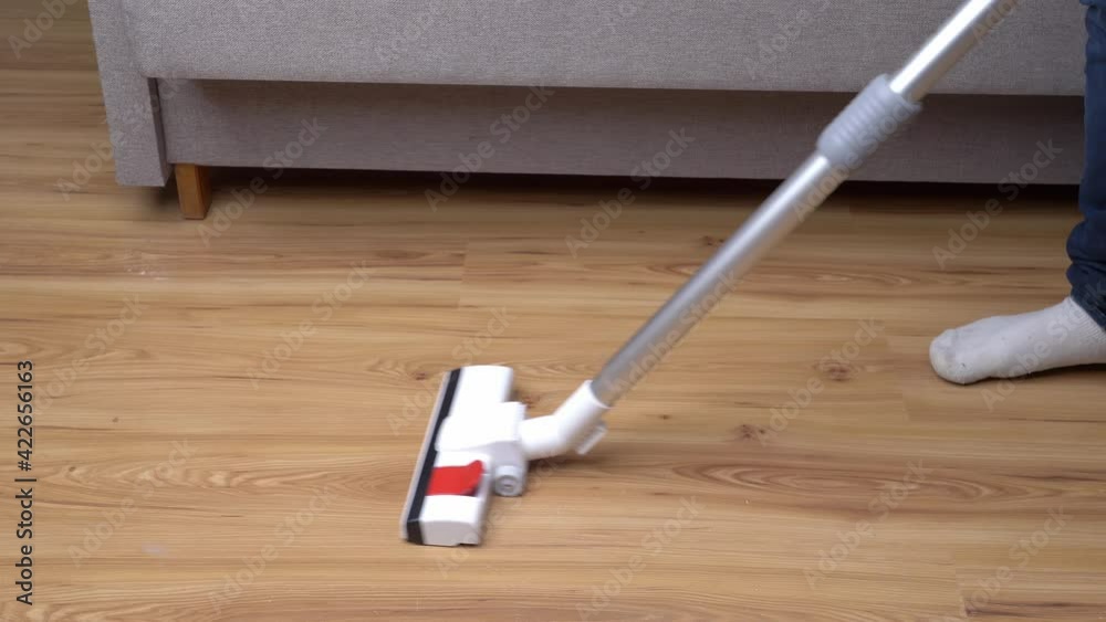 a man is engaged in cleaning from dirt at home with a vacuum cleaner. House cleaning and hygiene concept a man is engaged in cleaning from dirt at home with a vacuum cleaner. House cleaning and hygiene concept