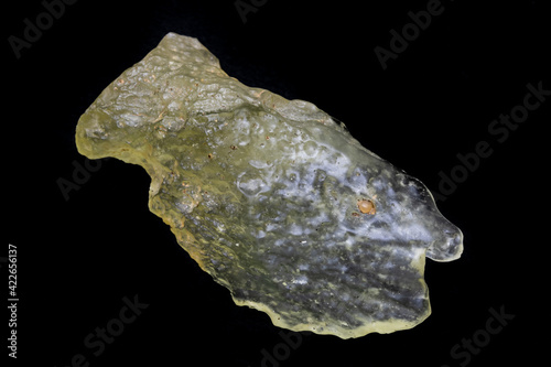 Yellow specimen of Libyan desert glass. Translucent to transparent, weighing 21.7 grams. Surface is smooth, mottled, with evidence of flowing motion. Photographed with black background in natural ligh