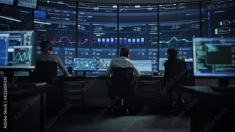 Professional IT Technical Support Specialists and Software Programmer Working on Computers in Monitoring Control Room with Digital Screens with Server Data, Blockchain Network and Surveillance Maps. 