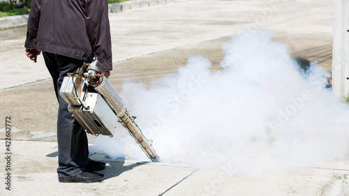 Man pointing smoke machine into manhole for pest control photo