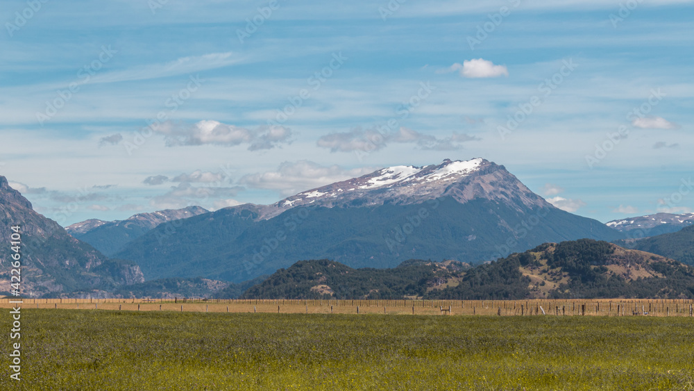 Fototapeta premium Día soleado en el campo con montes de fondo.