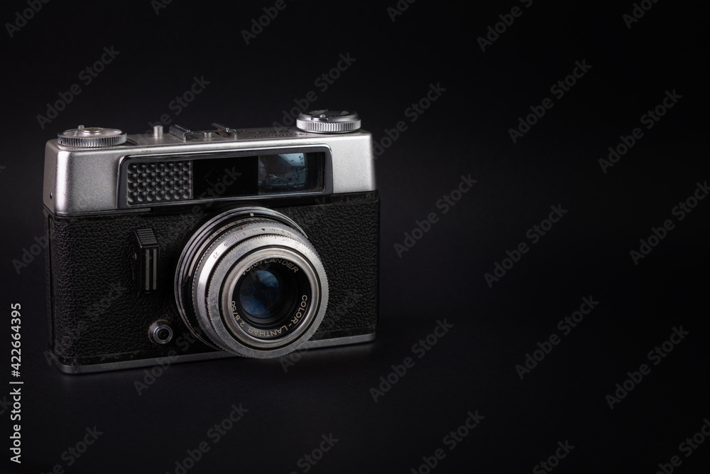 Old analog camera, in a black background