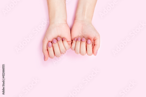 Beautiful female hands on a pink background. 