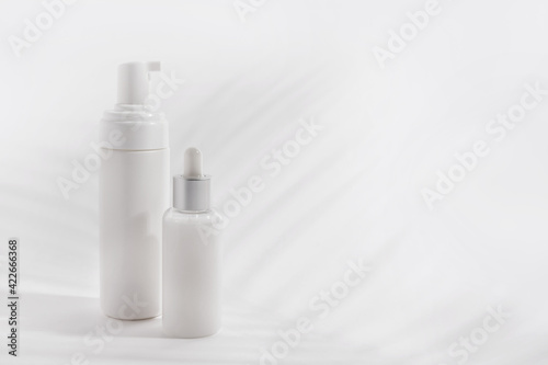 Foam container and bottle with serum on light background