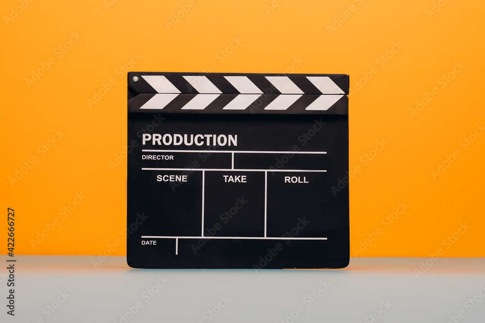 Clapperboard on yellow and teal blue background. Filmmaker profession. 