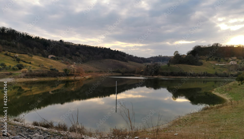 Riflessi in un piccolo lago immerso nel verde delle colline marchigiane Riflessi in un piccolo lago immerso nel verde delle colline marchigiane