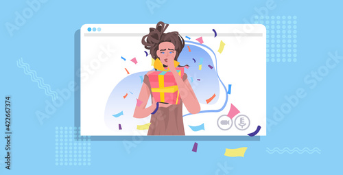 woman celebrating online party girl in web browser window holding wrapped gift box