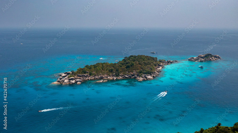 Aerial drone view of boats around the tree covered island of Ko Similan in Thailand 2021