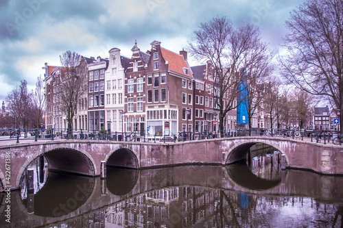 beatiful bridge on the canals of amsterdam with its typical houses