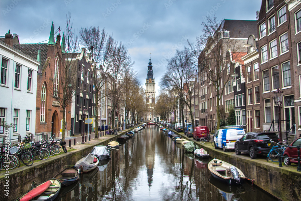 a beatiful canal of amsterdam with a church in the back