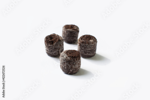 Isolated compacted peat pellets (pod) for seed starting are used by gardeners. Peat is harvested unsustainably and has led to irreversible damage. Coconut coir is a green alternative for germinating photo