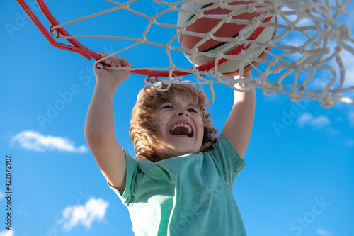 Basketball kid player running up and dunking the ball